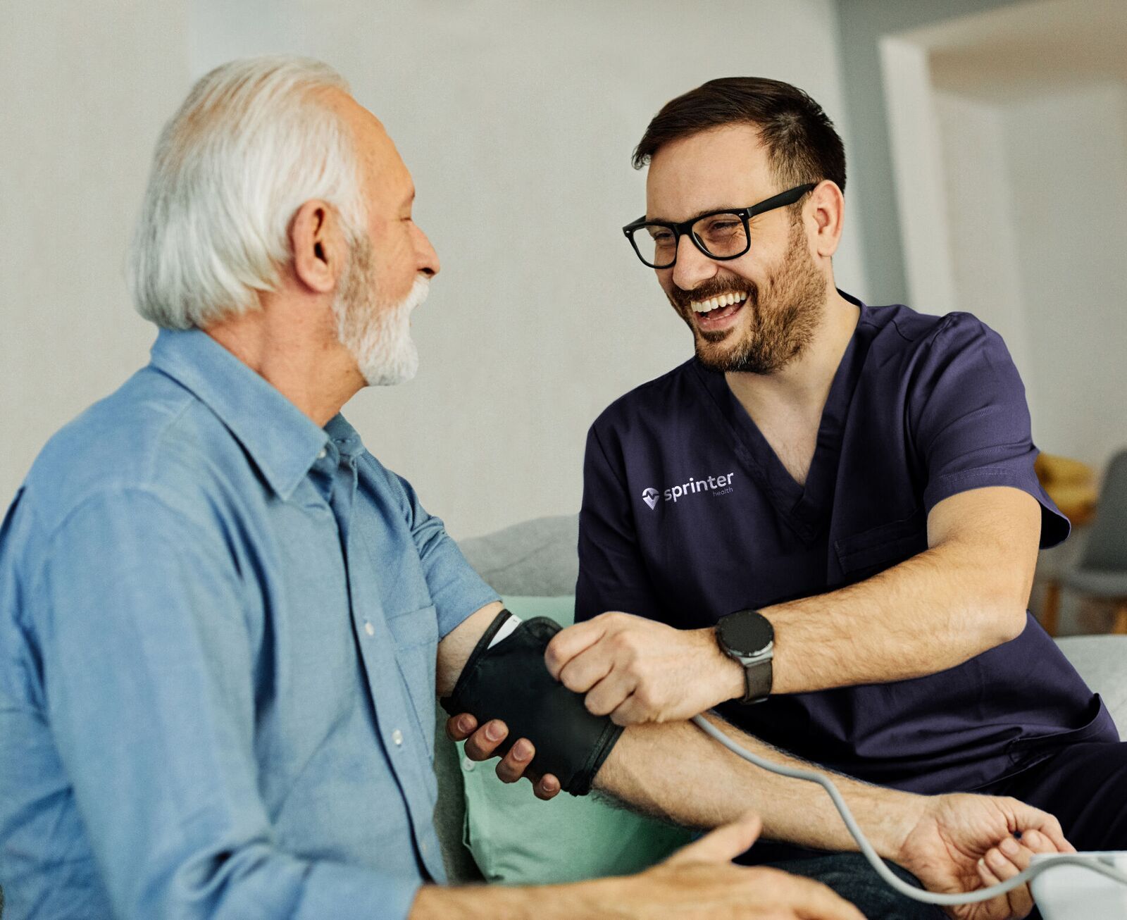A Sprinter clinician taking a senior patient's blood pressure at home